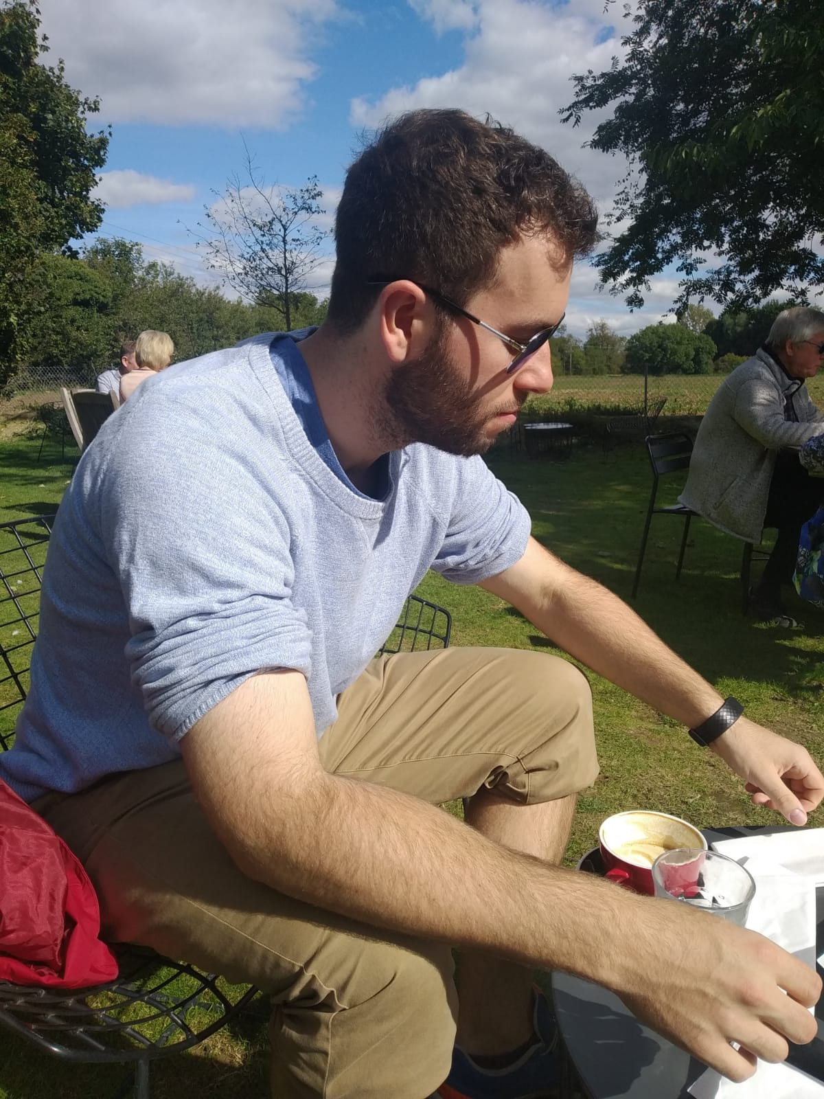 ARU PhD student Jack pictured outside with a coffee from Hot Numbers cafe.