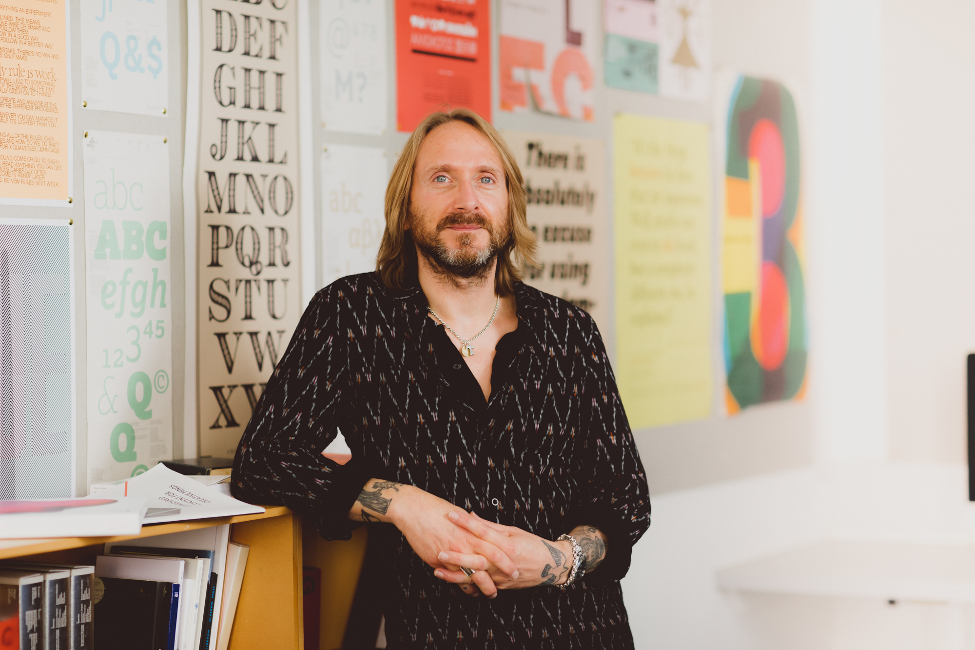 Graphic Design lecturer Nick Jeeves leaning against a shelf