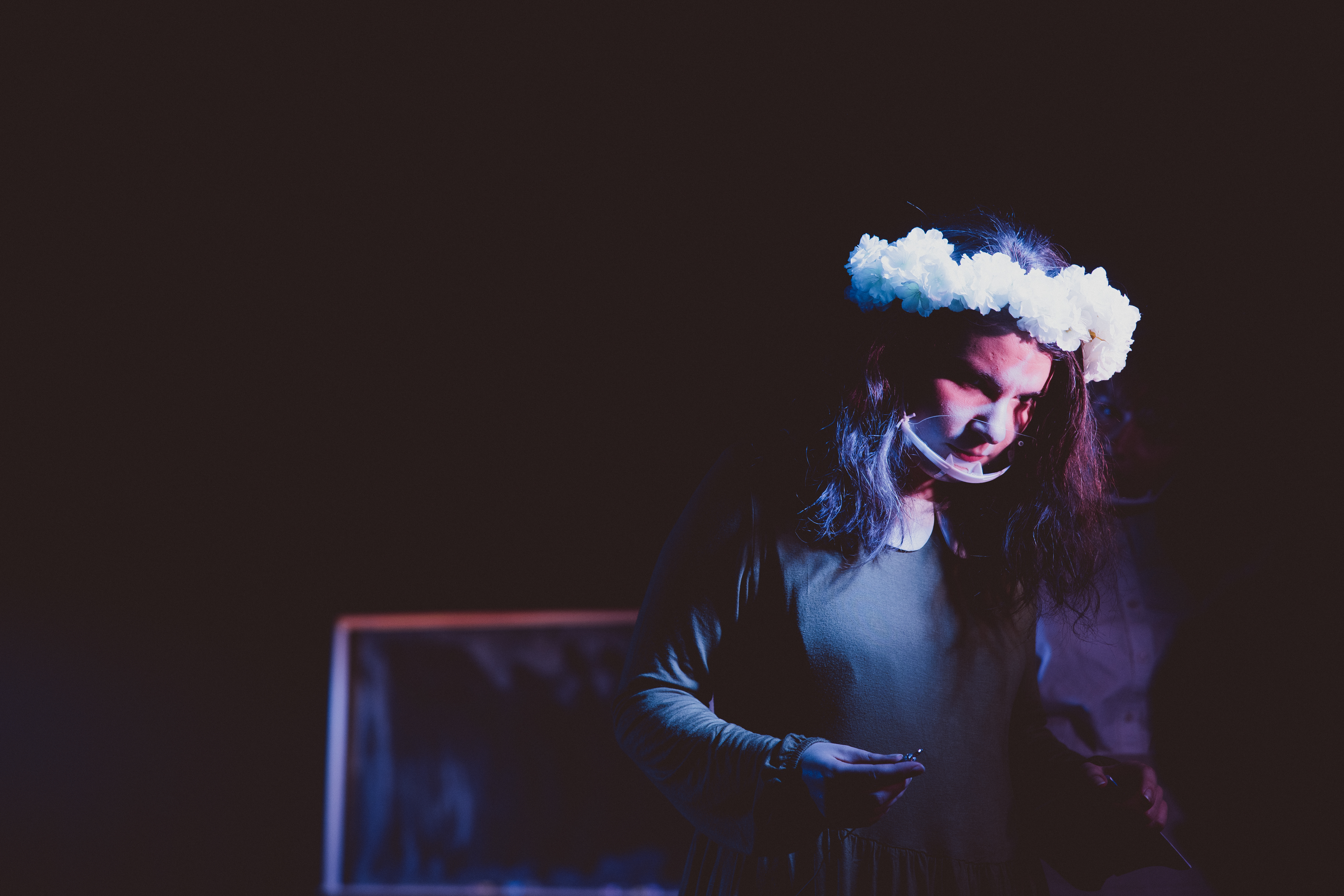 A student being spotlighted performing on stage.