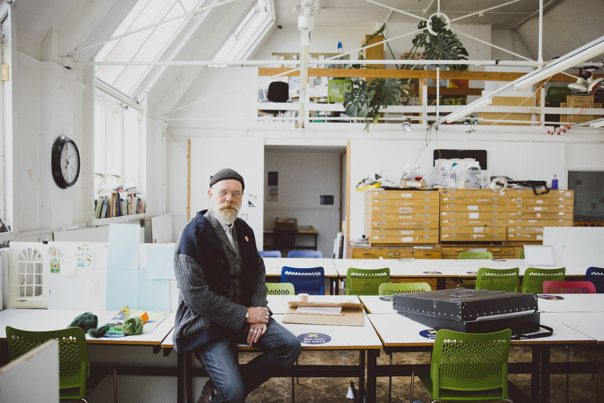 Chris Draper sitting on a desk in the illustration studio
