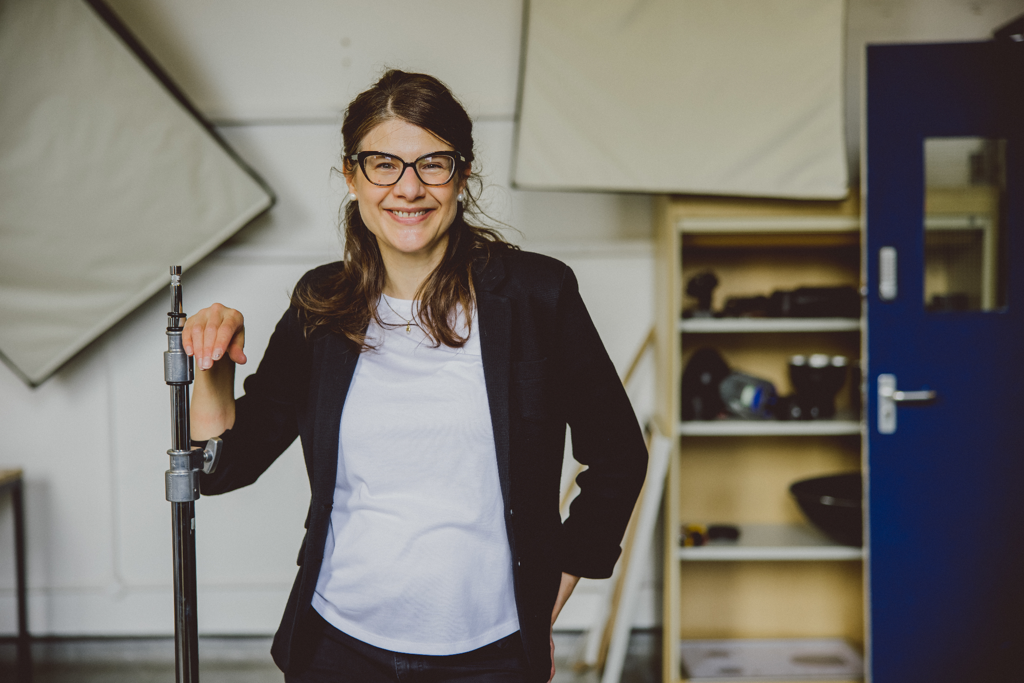 Julia Johnson leaning on a tripod in the photography studio