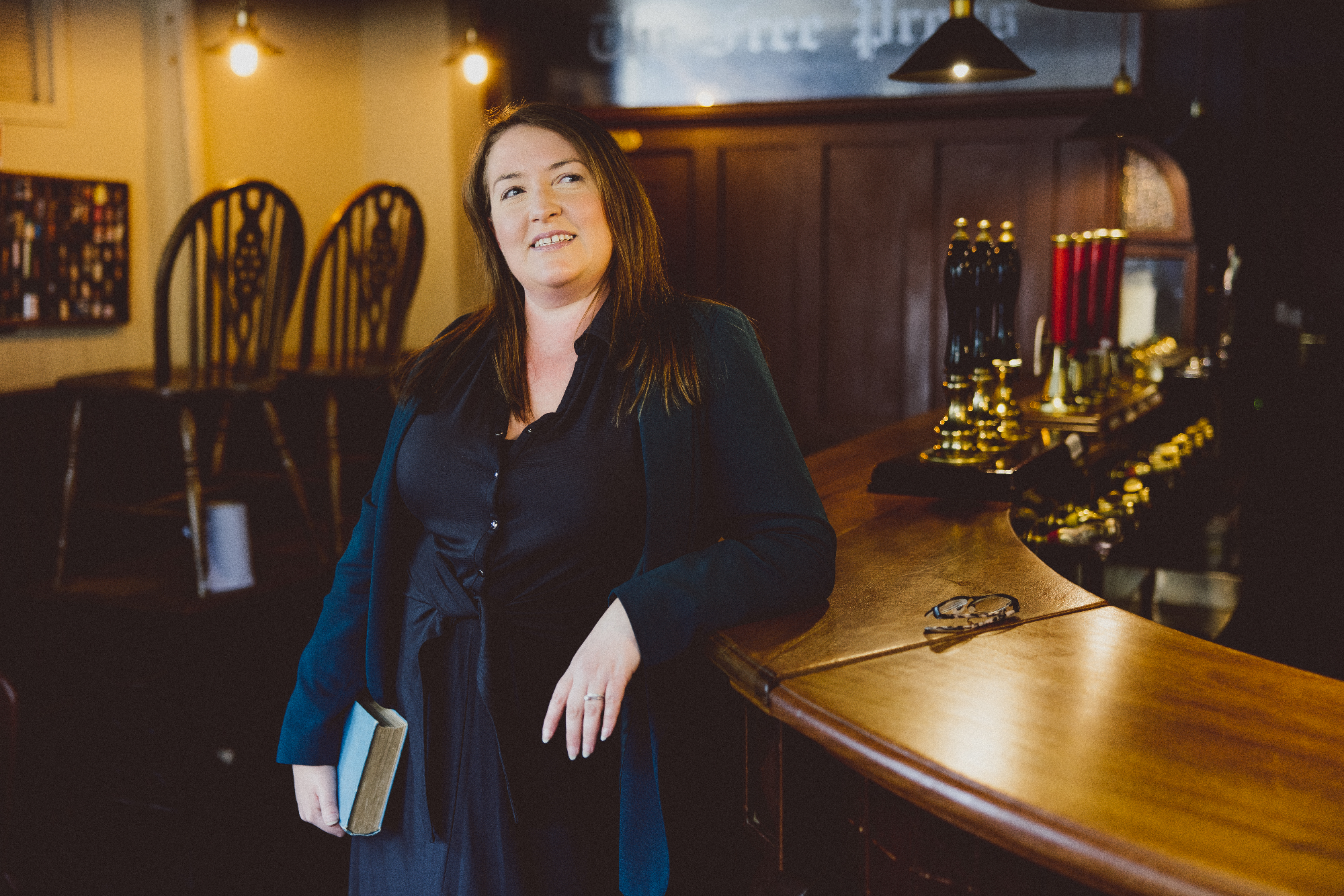 Rachel Ryder leaning on a bar in a pub