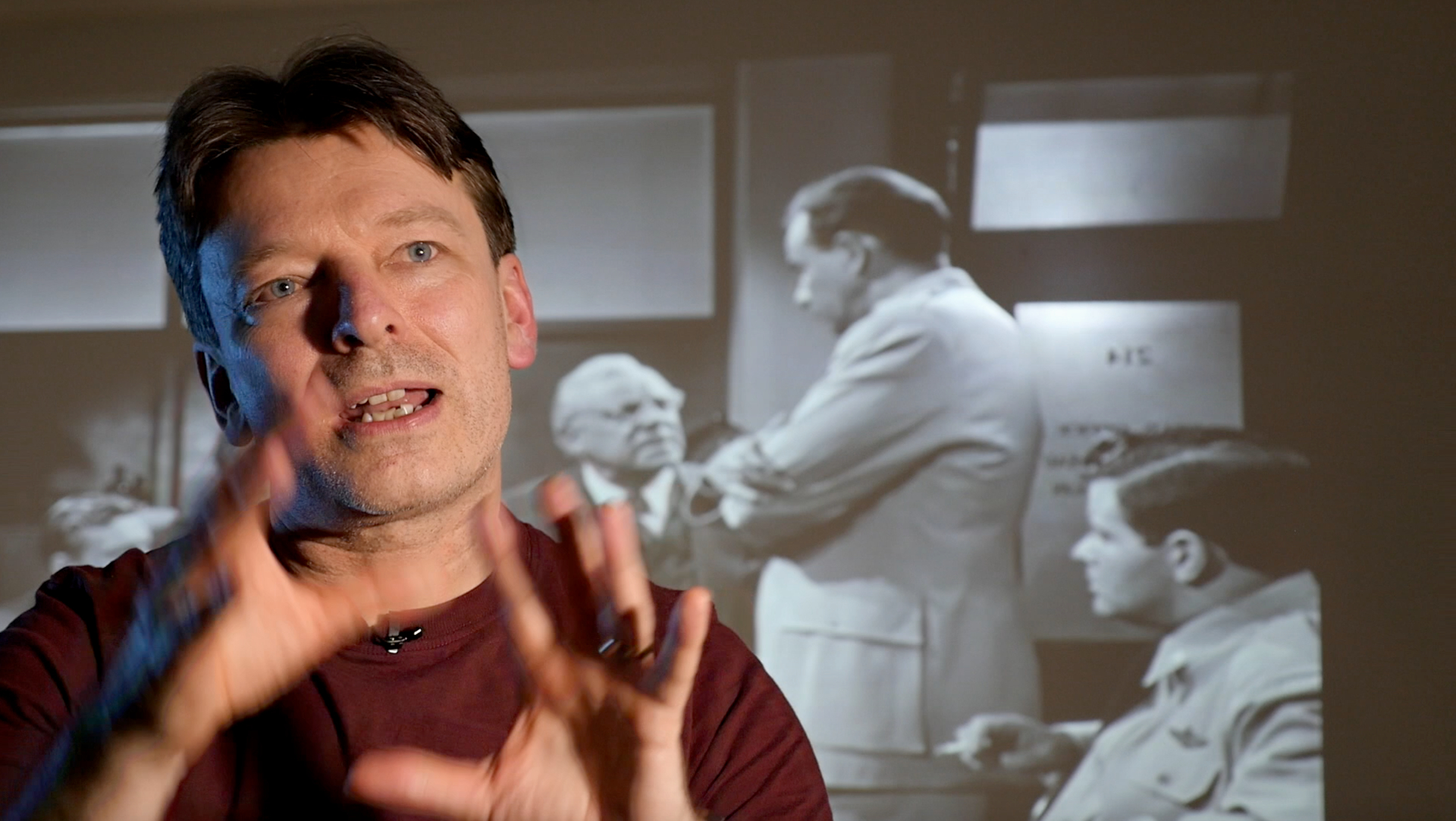 Toby Venables talking in front of black and white film