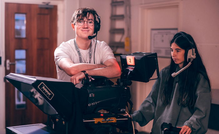 A male and female student operating a tv camera